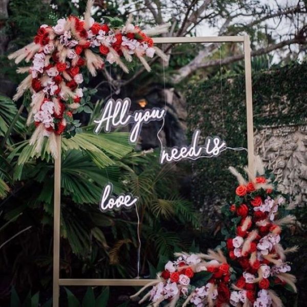 All you need is love faux neon sign in 3 pieces shown at a wedding - from Custom Neon®