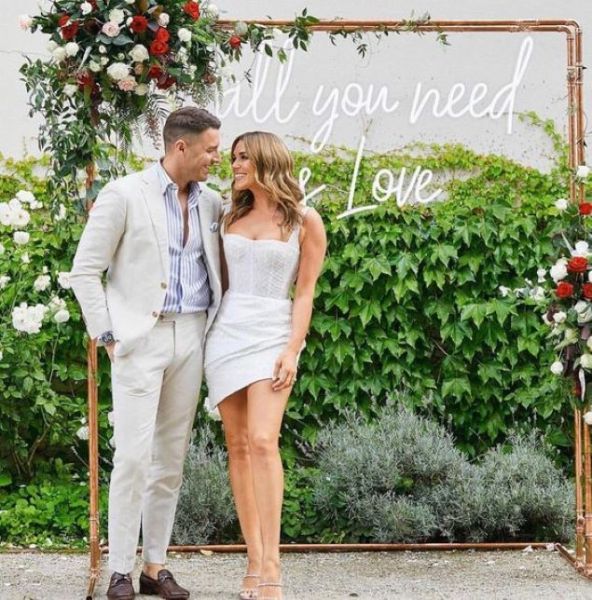 Large All You Need is Love white LED neon sign in photo booth at wedding of @georgiealove & @leeroyelliot - made by Custom NeonÂ®