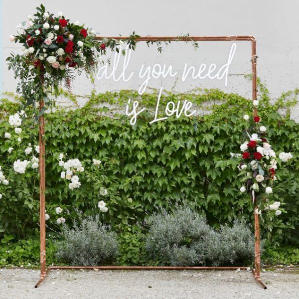 Large All You Need is Love white LED neon sign shown on frame at wedding of @georgiealove & @leeroyelliot - made by Custom NeonÂ®