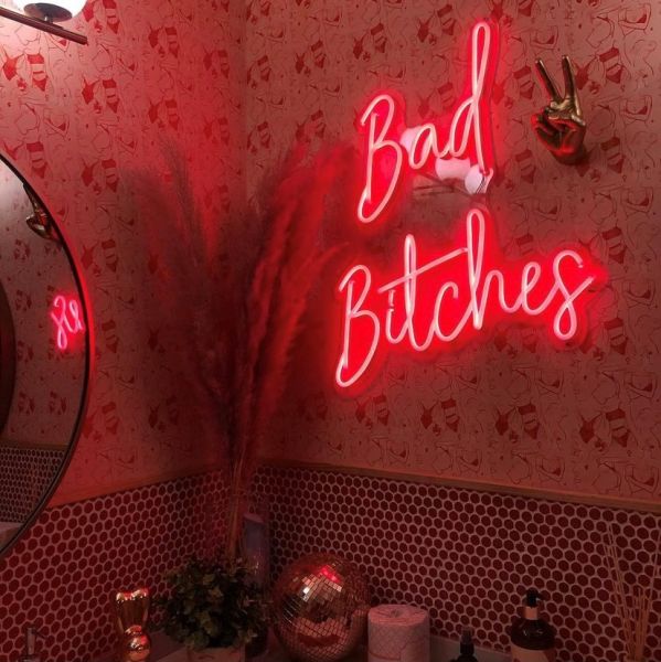 Red Bad Bitches Custom Neon® sign shown wall mounted in a bathroom - photo @lilaavatara