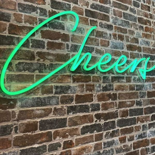 Cheers LED Neon Bar Sign in green on dark brick wall - Custom Neon®