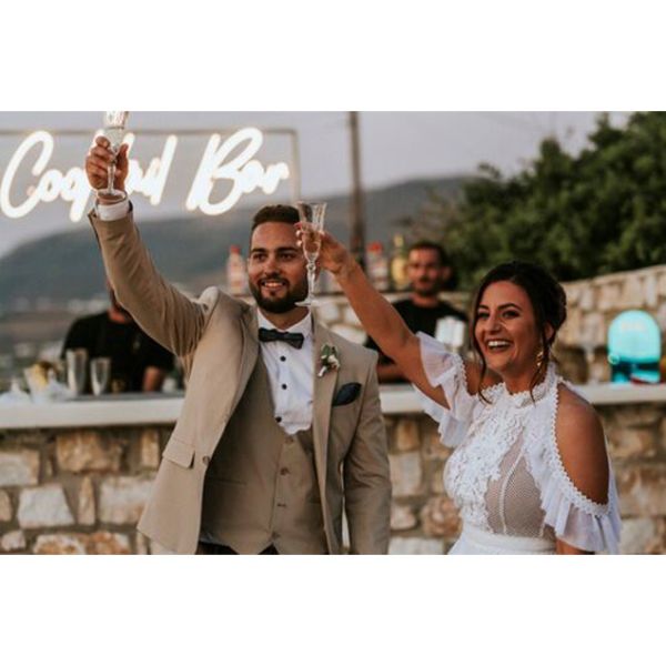 Cocktail Bar Neon Sign shown behind the bride and groom at a wedding - photo from CustomNeon.co.uk