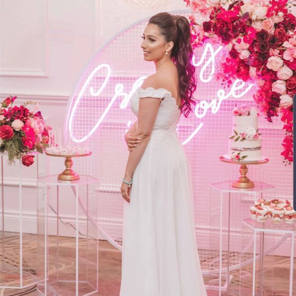 Crazy In Love Wedding Sign in brilliant LED neon flex shown in pink with the beautiful bride, wedding florals and cakes - photo from CustomNeon.co.uk