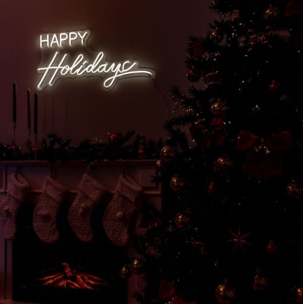 CUSTOM NEON® Happy Holidays light sign above the fireplace surrounded by Christmas decor