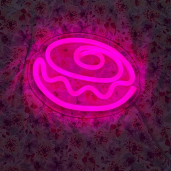 Pink Donut Line Art Sign from Custom Neon® shown in a dark room 