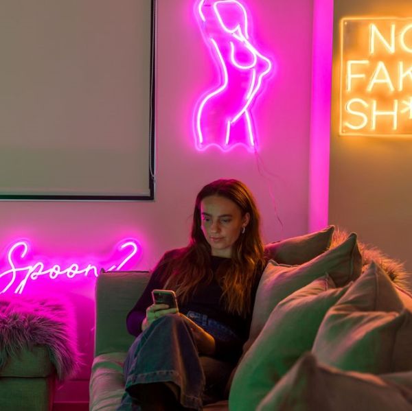 Neon flex line drawing of a nude woman in dark pink on a living room wall from Custom Neon®