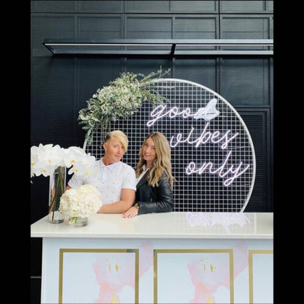 Good Vibes Only LED neon sign in 3 pieces shown on a mesh screen at an event - photo from CustomNeon.co.uk