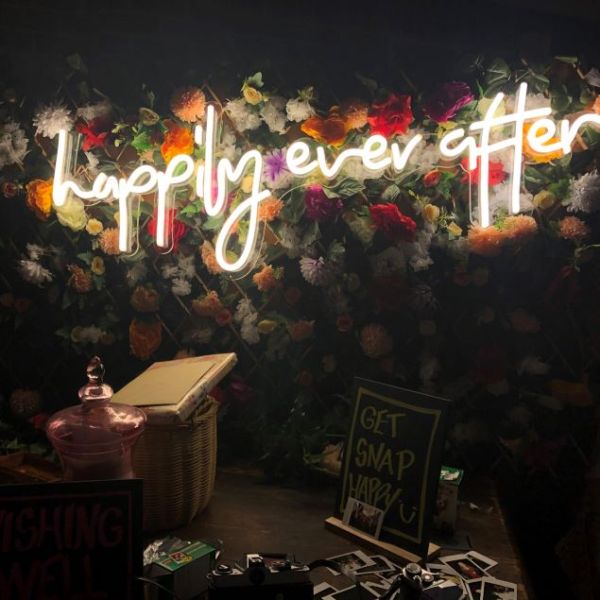 Happily Ever After LED neon on a flower wall highlighting the wishing well and guest photo area - from Custom Neon UK