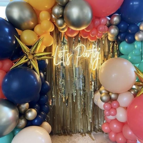 Let's Party LED neon light in soft white surrounded by giant balloons and party decor - Custom Neon® @customneon