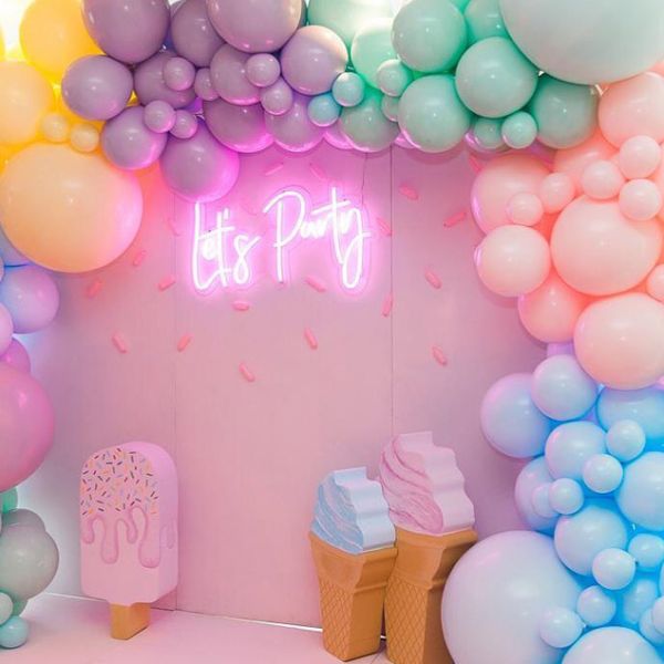Let's Party portable LED neon sign shown on the photo wall of a kids party - photo from CustomNeon.co.uk  @customneon
