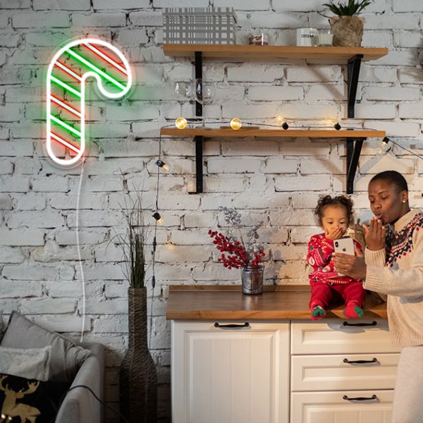 Light Up Candy Cane on white brick wall with Christmas lights & decorations - CUSTOM NEON®