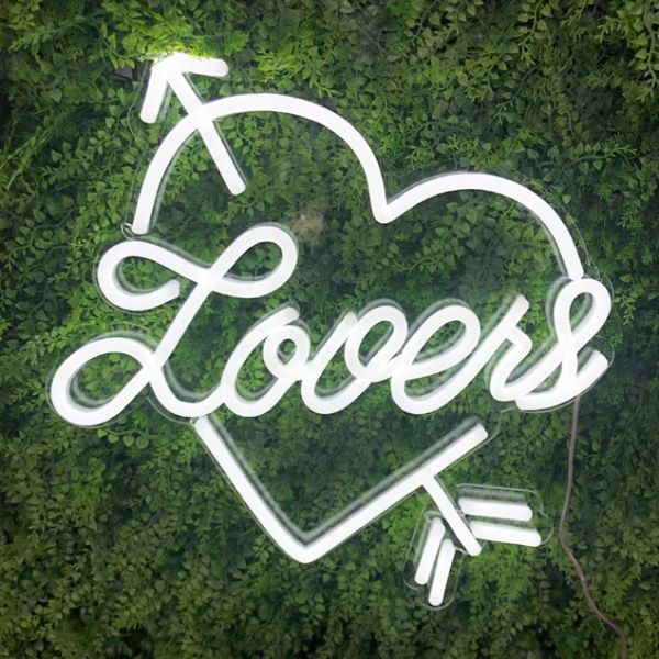 Heart shaped neon flex with Lovers written inside shown on green wall - from Custom Neon®