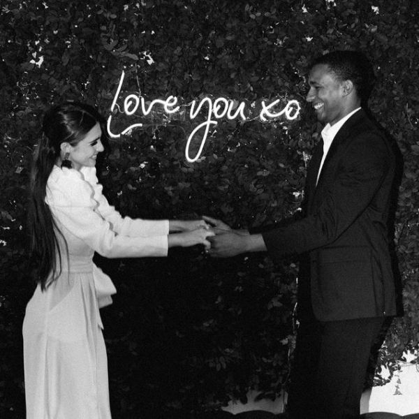 Love You XO LED neon sign on green wall while happy couple hold hands - sign by CustomNeon.co.uk / photo by candileonardphotography.com