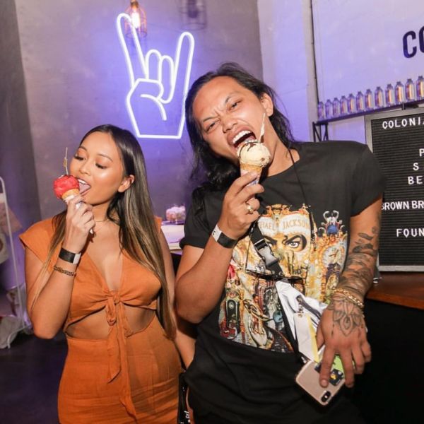 Rock On Emoji LED Neon Sign shown in white, mounted on the wall of a store - photo from CustomNeon.co.uk