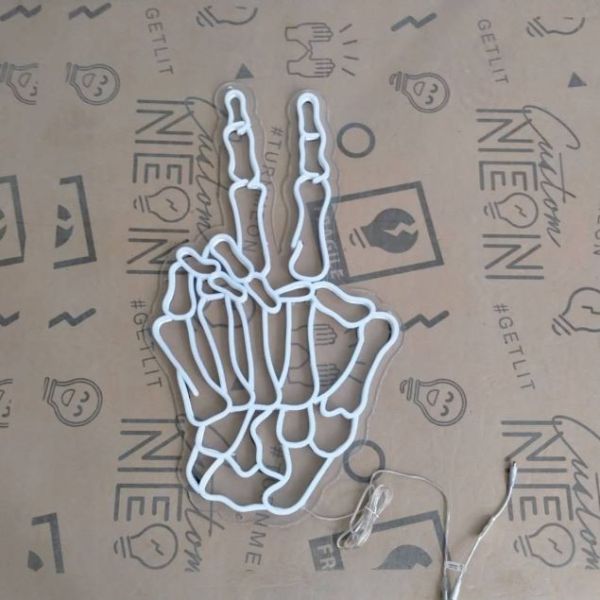 Skeleton hand peace sign in LED neon flex by Custom Neon® shown turned off.