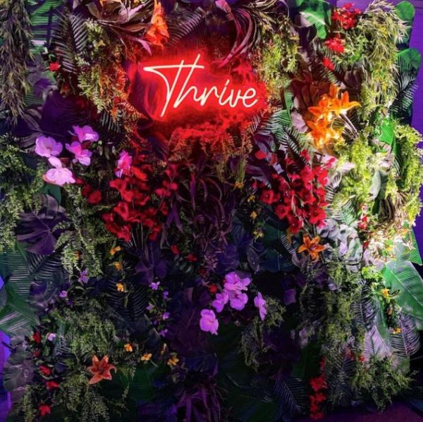 Thrive red Custom Neon® light surrounded by florals @csdesignandevents