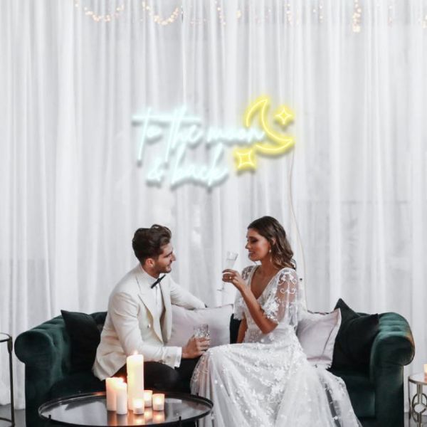 To the Moon & Back LED neon sign mock up with a moon & stars shown at a wedding - from CustomNeon.co.uk