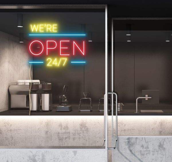 WE'RE OPEN 24/7 in brilliant yellow and red, with bright blue lines shown in a cafe window - from CustomNeon.co.uk