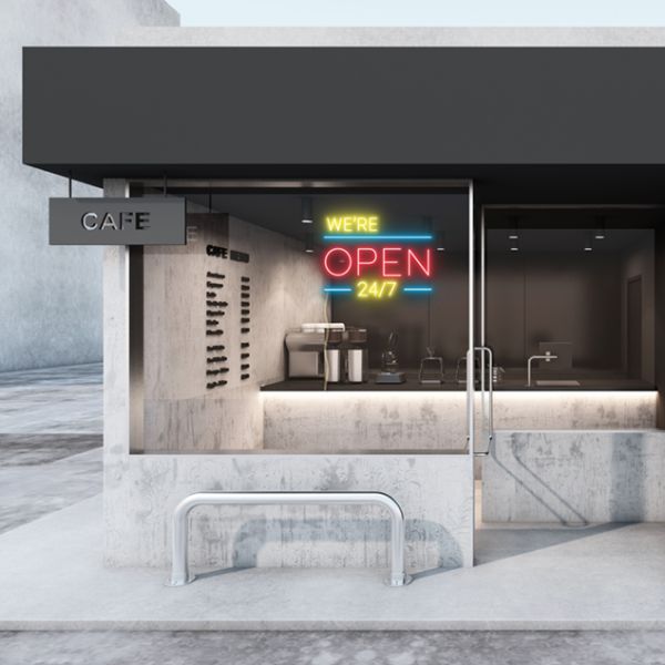 WE'RE OPEN 24/7 in brilliant yellow and red, with bright blue lines shown in a cafe window - from CustomNeon.co.uk