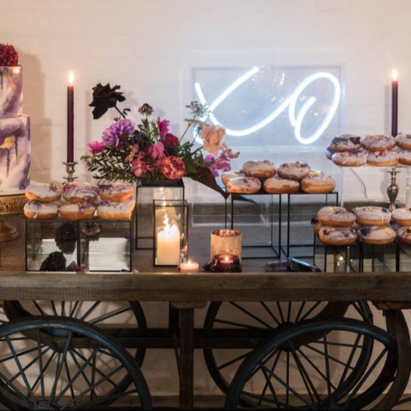 XO Light Up Sign in Acrylic Box shown as wedding decor behind the sweets table - from CustomNeon.co.uk