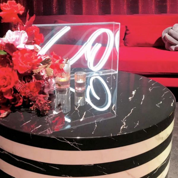 XO tabletop LED neon sign in acrylic box shown on a table during an event - photo from CustomNeon.co.uk