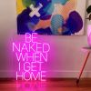 Be Naked When I Get Home LED neon sign shown on the floor beneath a painting - photo from CustomNeon.co.uk