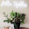 Better Together neon wedding sign wall mounted above the wedding photo table - photo from CustomNeon.co.uk
