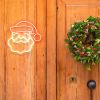 CUSTOM NEON® Light Up Santa on a wooden door beside a traditional Christmas wreath 