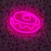 Pink Donut Line Art Sign from Custom Neon® shown in a dark room 