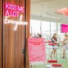 Kiss Me A Lot Everywhere LED Neon Sign shown hung from the entrance to a Valentine's Day event - photo CustomNeon.co.uk