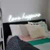 Love Happens faux neon sign above bed as bedroom decor - from Custom Neon®