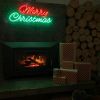 Red & green Merry Christmas light sign mounted above a fireplace with wooden logs, presents & a basket of pinecones- by CUSTOM NEON® 