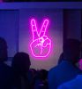 Neon Peace Sign neon light shown wall mounted in a busy restaurant
