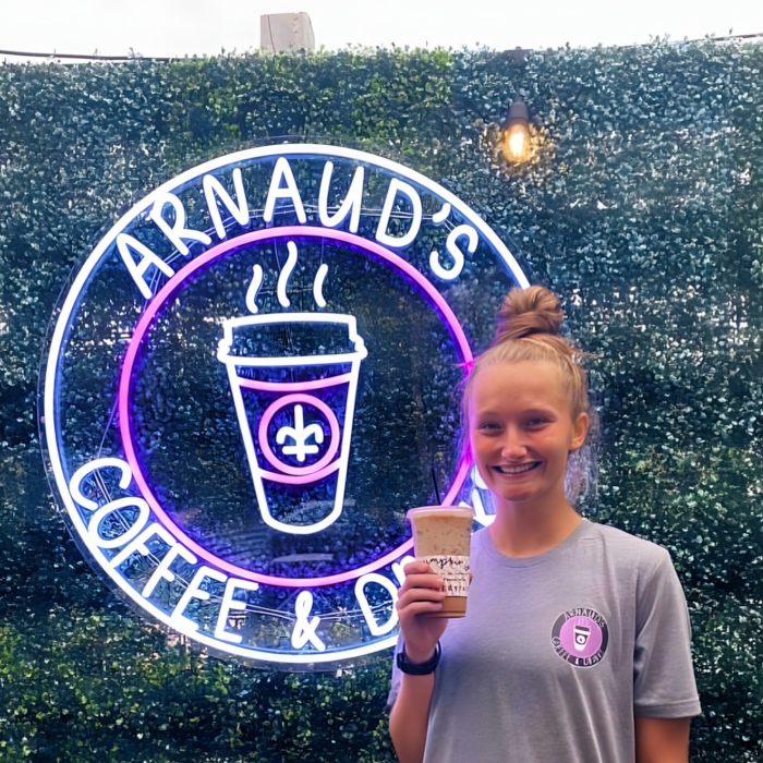 Purple and white waterproof Custom Neon® logo sign in the outdoor seating area @arnaudscoffee