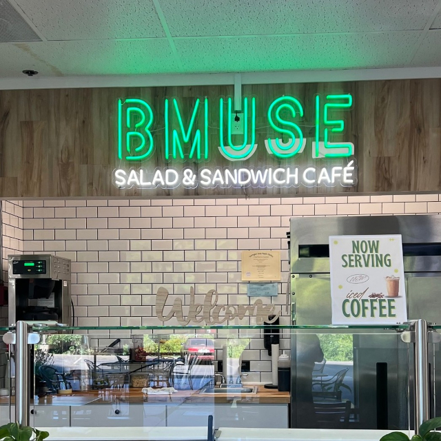 Green and white logo sign by Custom Neon® @bmusecafe.middlebury