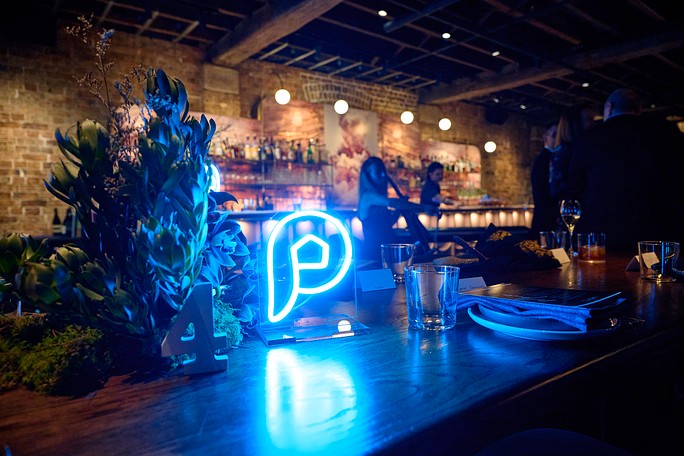 Blue illuminated centerpiece made by Custom Neon® on a restaurant table