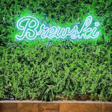 Green Brewski logo sign by Custom Neon® on greenwall @brewskirestaurants