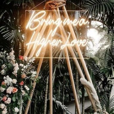 Bright me a higher love warm white Custom Neon® song lyric sign on a wooden teepee during a tropical outdoor wedding ceremony for the celebrity @vanessamorgan