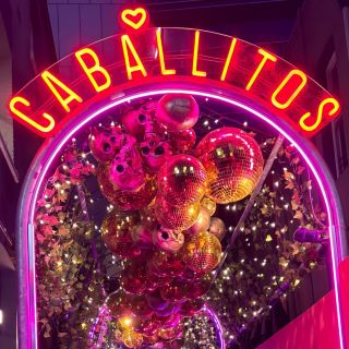 Red Custom Neon® sign on a neon arch outside the entrance to @caballitosperth