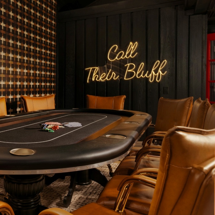 Call Their Bluff LED Custom Neon® sign on a dark wood panelled wall behind a poker table in a games room designed by Somerled