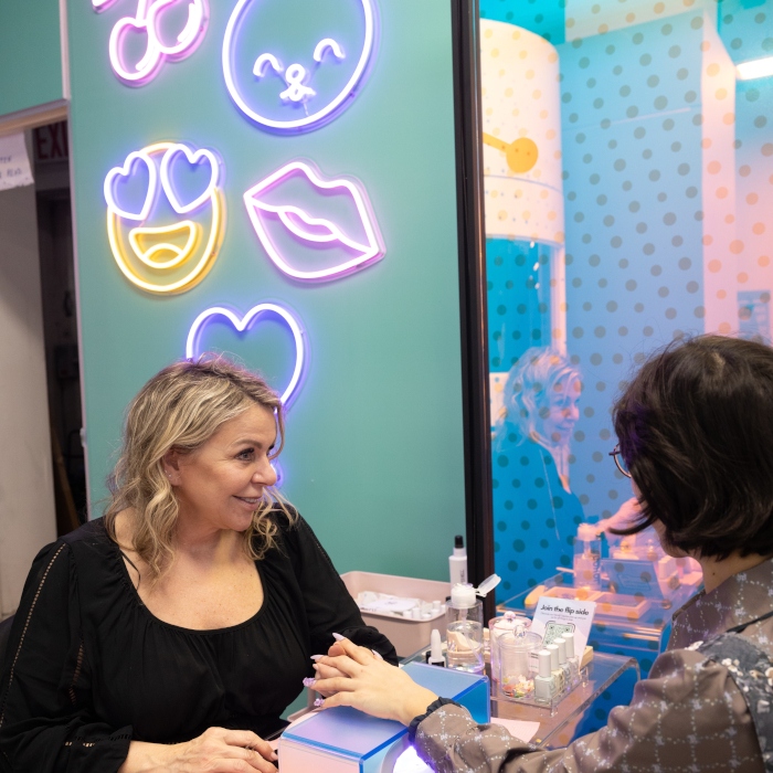 Custom Neon® LED neon emoji signs on a pale green wall in the Samsung Flip Side Pop-Ups
