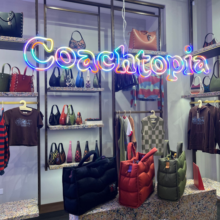 Coachtopia colourful LED neon logo sign made by Custom Neon&reg; using waste products hanging from the ceiling of the in The Grove, LA, Coach store