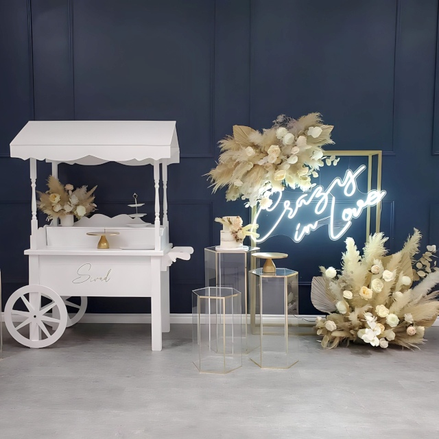 Custom Neon® Crazy in Love sign hung from a gold rectangular frame adorned with florals and pampas grass in neutral tones - event decor by @decorandfiesta