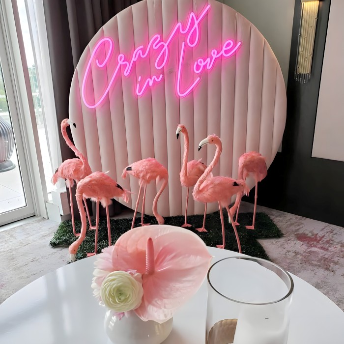 Custom Neon® pink Crazy in Love sign on a plush circular backdrop with pink flamingos in front - event decor by @decorandfiesta