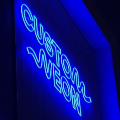 Dark blue Custom Neon® logo on the exterior of a building