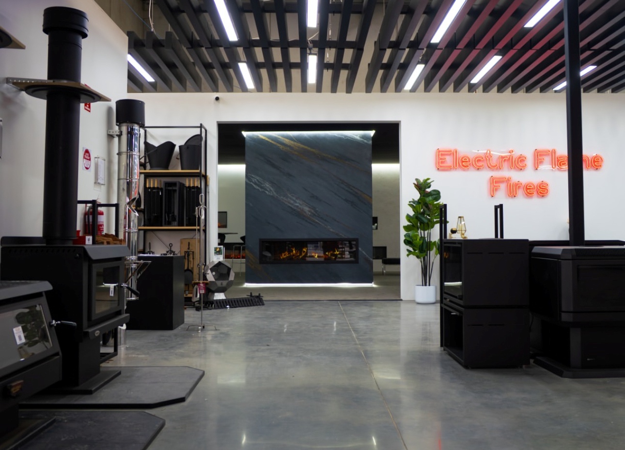 Electric Flame Fires red LED neon double lined wayfinding sign made by Custom Neon® mounted on a white wall in the Pivot Stoves showroom