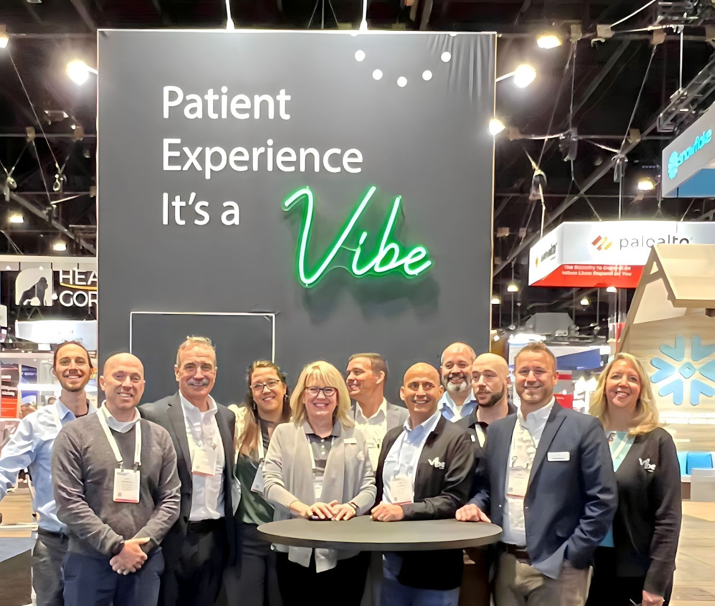 Custom Neon® green light up sign on the evideon.com banner at the @himss23 exhibition