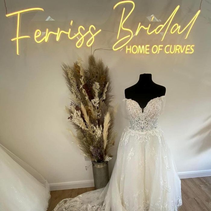 Ferris Bridal Home of Curves warm white Custom Neon® sign on a white wall in a bridal store