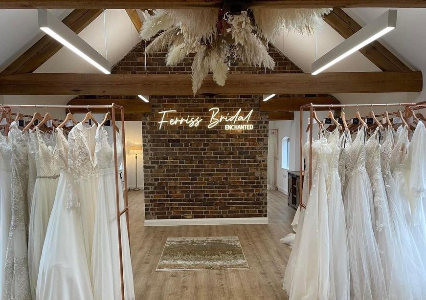 Custom Neon® warm white bridal shop sign on brick wall @ferrissbridalenchanted