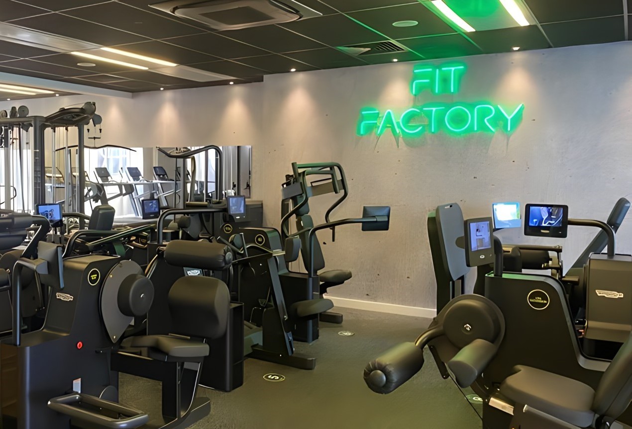 Fit Factory green Custom Neon® gym sign mounted on concrete wall @retrofitlondon